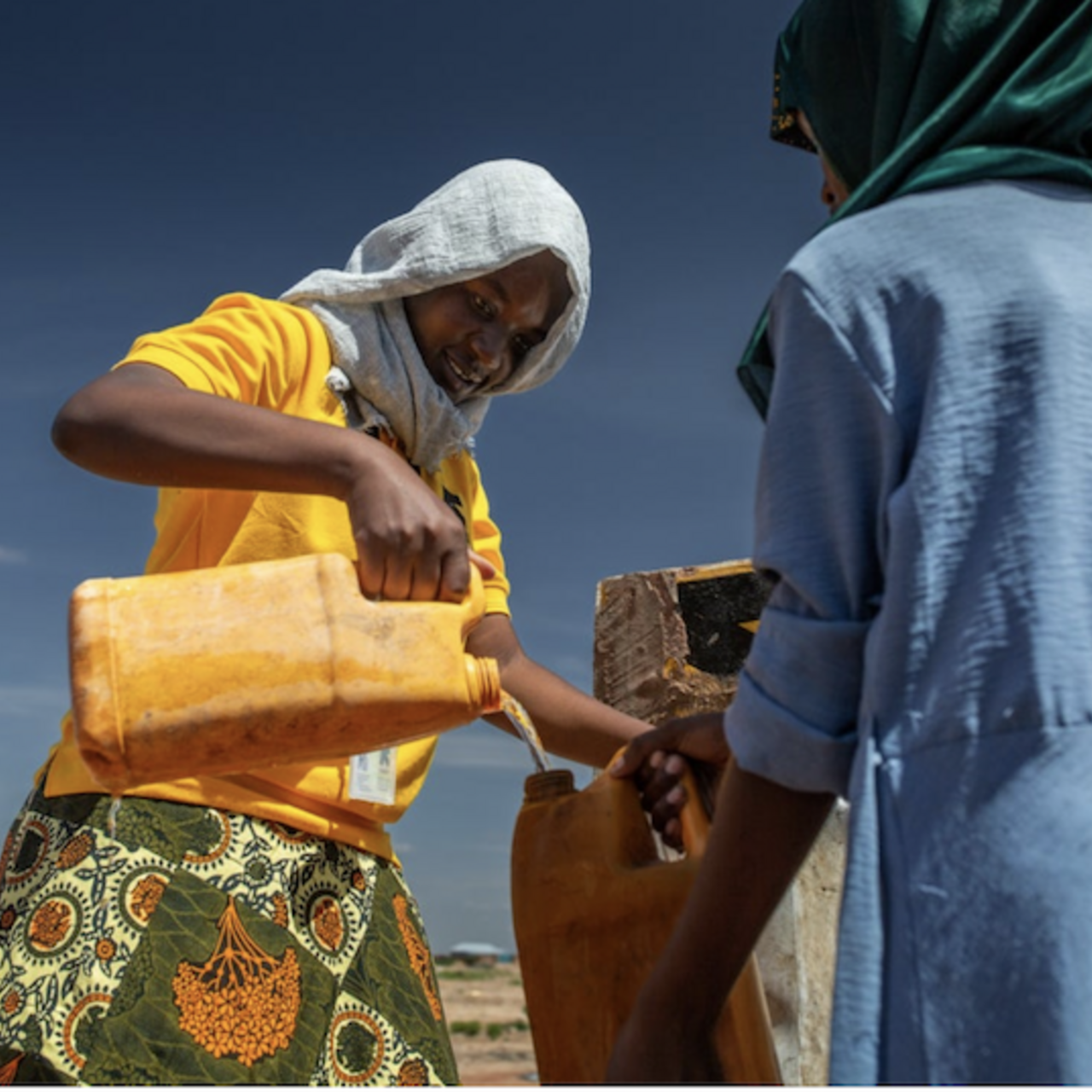 An IRC worker fills a jug with water